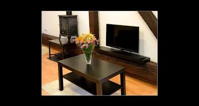 a living room with a vase of flowers on a table at 777 Apartments 2 in Kraków