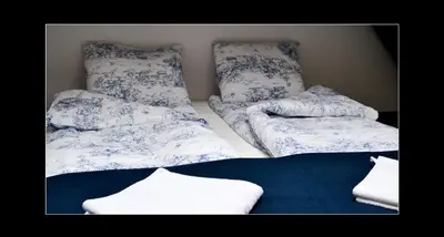 a room with two beds with blue and white sheets at 777 Apartments 2 in Kraków