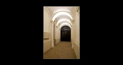 a hallway leading to a black door with an archway at 777 Apartments 2 in Kraków