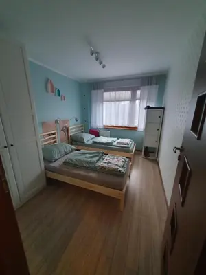 a small bedroom with two beds and a window at Apartament Daria in Jaworzno