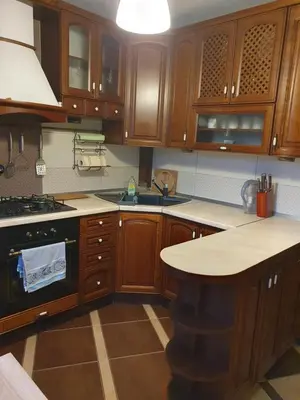 a kitchen with wooden cabinets and a sink and a stove at Apartament Daria in Jaworzno