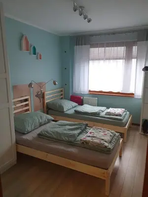 two twin beds in a room with a window at Apartament Daria in Jaworzno