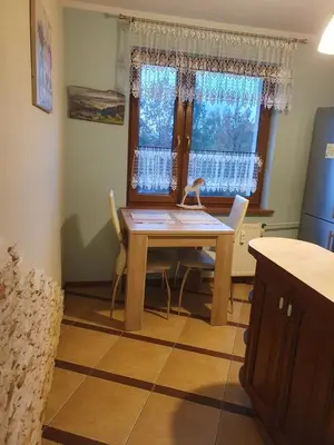 a kitchen with a table and chairs and a window at Apartament Daria in Jaworzno