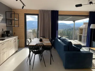 a living room with a blue couch and a table at Górne Chaty Zawoja in Zawoja