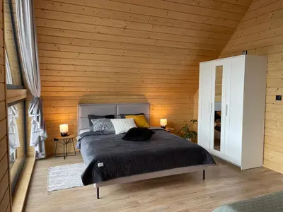 a bedroom with a bed in a wooden wall at Górne Chaty Zawoja in Zawoja