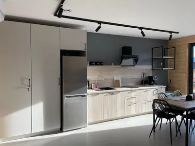 a kitchen with white cabinets and a table with chairs at Górne Chaty Zawoja in Zawoja