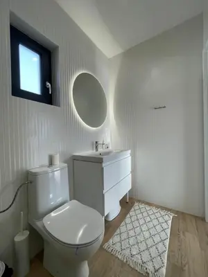 a white bathroom with a toilet and a sink at Górne Chaty Zawoja in Zawoja