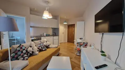 a living room with a couch and a kitchen at Apartament Wieliczka in Wieliczka