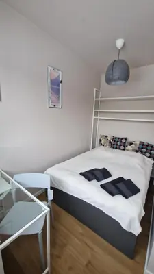 a small bedroom with a bed with white sheets at Apartament Wieliczka in Wieliczka