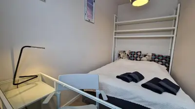 a small bedroom with a bed and a chair at Apartament Wieliczka in Wieliczka