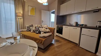 a living room with a couch and a kitchen at Apartament Wieliczka in Wieliczka