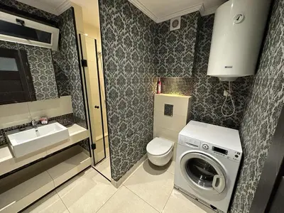 a bathroom with a washing machine and a sink at Jaga Family Apartment air conditioner and free parking in Kraków