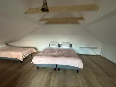 two beds in a room with wooden floors at Jaga Family Apartment air conditioner and free parking in Kraków