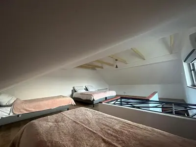 a attic room with three beds and a window at Jaga Family Apartment air conditioner and free parking in Kraków