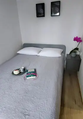 a bedroom with a bed with a tray of food on it at MR HOME APARTMENTS - Nullo in Kraków