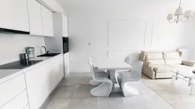 a white kitchen with a table and chairs and a couch at Augustiańska 24 by Homeprime in Kraków