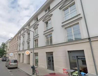 a white building on a street with a car parked outside at Augustiańska 24 by Homeprime in Kraków