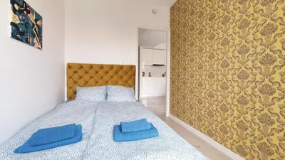 a bedroom with a bed with two blue pillows on it at Augustiańska 24 by Homeprime in Kraków