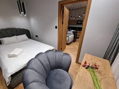 a room with a bed and a table and a chair at Apartamenty Sebastiana in Kraków
