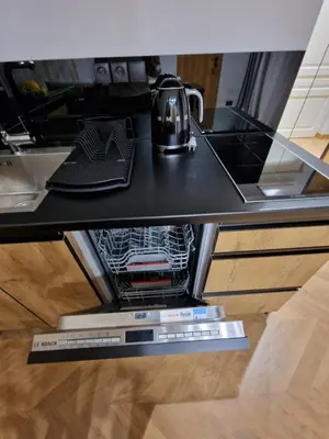 a kitchen counter with a tea kettle in the dishwasher at Apartamenty Sebastiana in Kraków