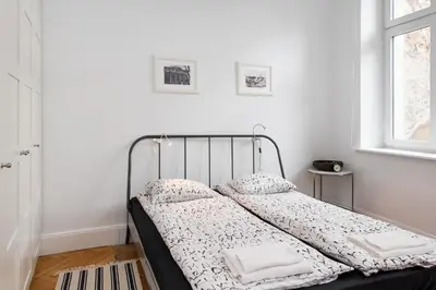 a bed in a white room with two pillows at Krakow 25 Old Town Apartament in Kraków