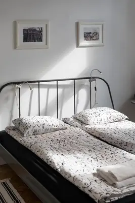 a bed with a black frame and white sheets and pillows at Krakow 25 Old Town Apartament in Kraków