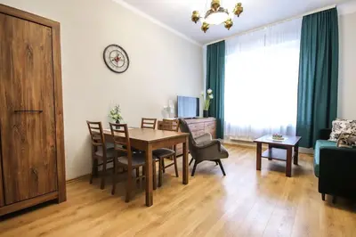 a living room with a table and chairs and a dining room at Piękny apartament w centrum Krakowskiego Kazimierza in Kraków