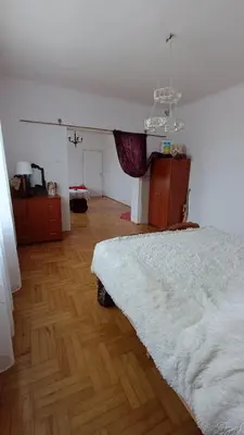 a bedroom with a white bed and a wooden floor at Dom na szlaku Krakowskim in Łączany