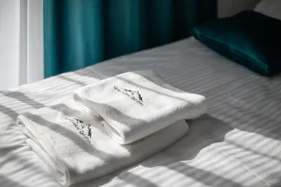 a pile of towels sitting on top of a bed at Gorczański Zakątek Jacuzzi & Sauna in Niedźwiedź