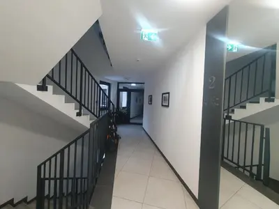 a hallway with stairs with lights on the wall at Fly_to_Cracow_18 in Kraków