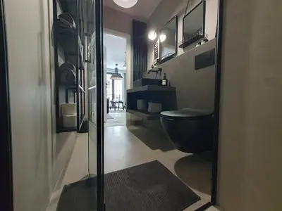 a bathroom with a black toilet and a glass door at Fly_to_Cracow_18 in Kraków