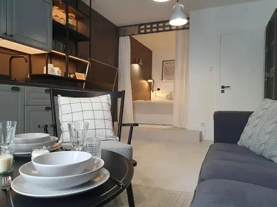 a living room with a table with plates on it at Fly_to_Cracow_18 in Kraków