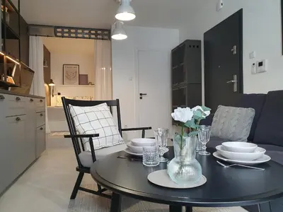a black dining room table with plates and flowers on it at Fly_to_Cracow_18 in Kraków