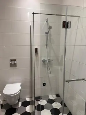 a bathroom with a toilet and a glass shower at Centrum Apartamenty Stare Miasto in Kraków