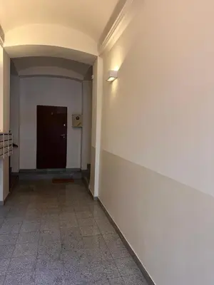 a hallway with a white wall and a door at Centrum Apartamenty Stare Miasto in Kraków