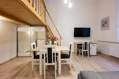 a dining room with a table and chairs and a tv at Native Apartments Dietla 17 in Kraków