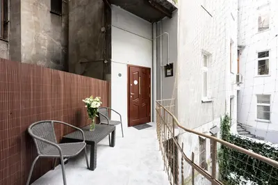 a patio with two chairs and a table and a door at Native Apartments Dietla 17 in Kraków
