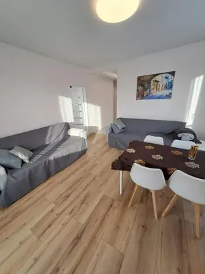 a living room with a table and a couch at Apartamenty Orawska 14 HEMMA in Kraków
