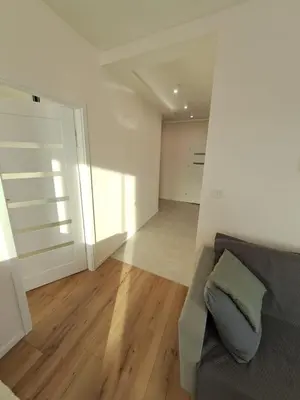 a living room with a couch and wooden floors at Apartamenty Orawska 14 HEMMA in Kraków