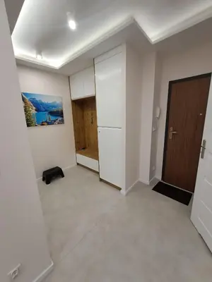 an empty room with a refrigerator and a door at Apartamenty Orawska 14 HEMMA in Kraków