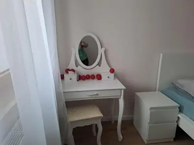 a bedroom with a dressing table with a mirror at Apartamenty Orawska 14 HEMMA in Kraków