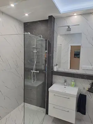 a bathroom with a shower and a sink at Apartamenty Orawska 14 HEMMA in Kraków
