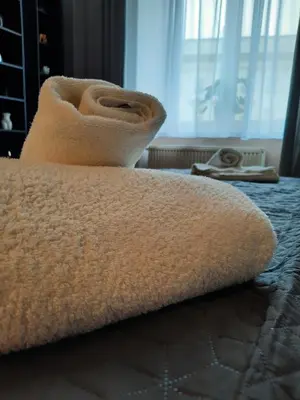 a towel sitting on top of a bed at Luxury Senate Apartment in Kraków