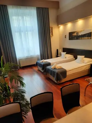 a hotel room with two beds and a table and chairs at Luxury Senate Apartment in Kraków
