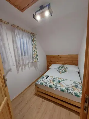 a small bedroom with a bed and a window at Skalne Rancho - BALIA, MASAŻ in Rabka-Zdroj