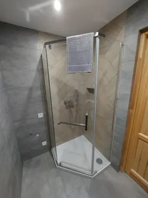 a shower stall with a towel hanging on a pole at Skalne Rancho - BALIA, MASAŻ in Rabka-Zdroj