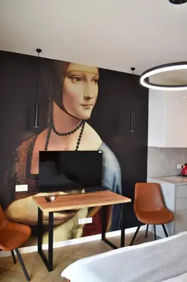 a painting of a woman on a wall with a table at Tutu Kraków in Kraków