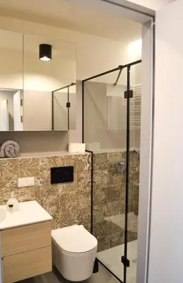 a bathroom with a toilet and a glass shower at Tutu Kraków in Kraków