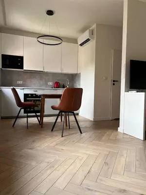 a living room with a table and chairs and a kitchen at Tutu Kraków in Kraków