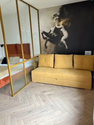 a couch in a room with a painting on the wall at Tutu Kraków in Kraków
